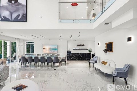 A living room with a white couch, grey chairs, and a large painting on the wall.