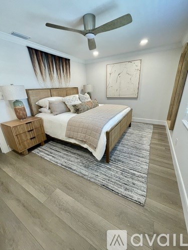 A bedroom with a bed, nightstand, and a ceiling fan.