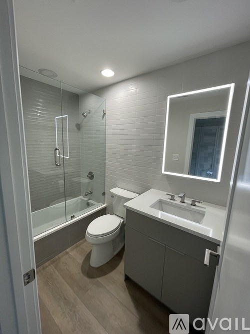 A modern bathroom with a toilet, sink, and shower.
