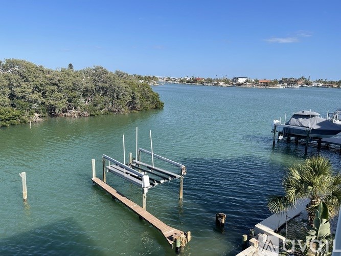 A dock extends into a body of water with a boat tied to it.