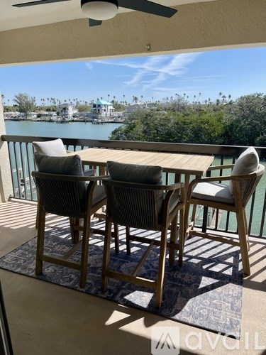 A patio with a table and chairs overlooking a body of water.