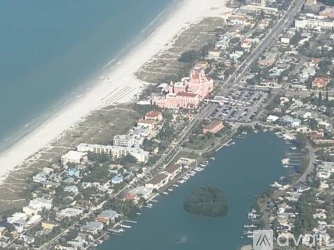 A coastal city with a large body of water and a prominent pink building.
