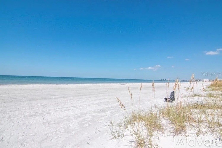 A beach with white sand and a clear blue sky.