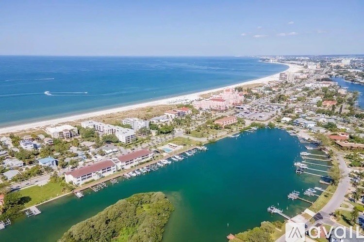 A bird's eye view of a coastal town with a marina and a beach.