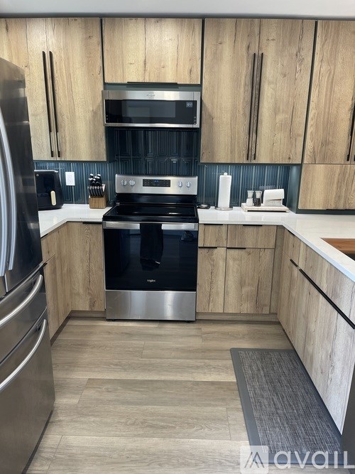 A modern kitchen with wooden cabinets and stainless steel appliances.