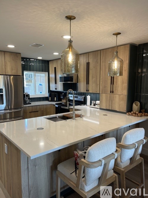 A kitchen with a white countertop and wooden cabinets.