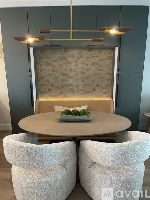 A modern dining room with a round table and two chairs.