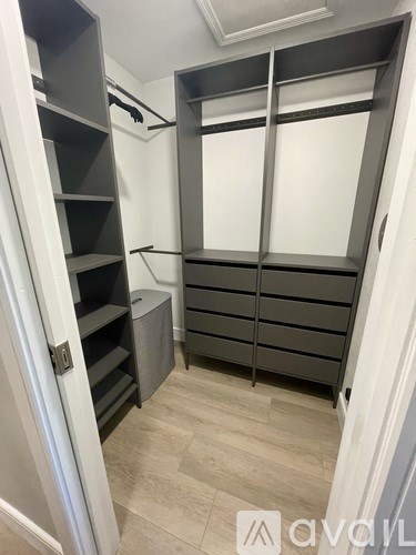A small walk-in closet with shelves and drawers.