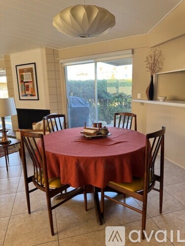 A dining room with a round table and chairs.