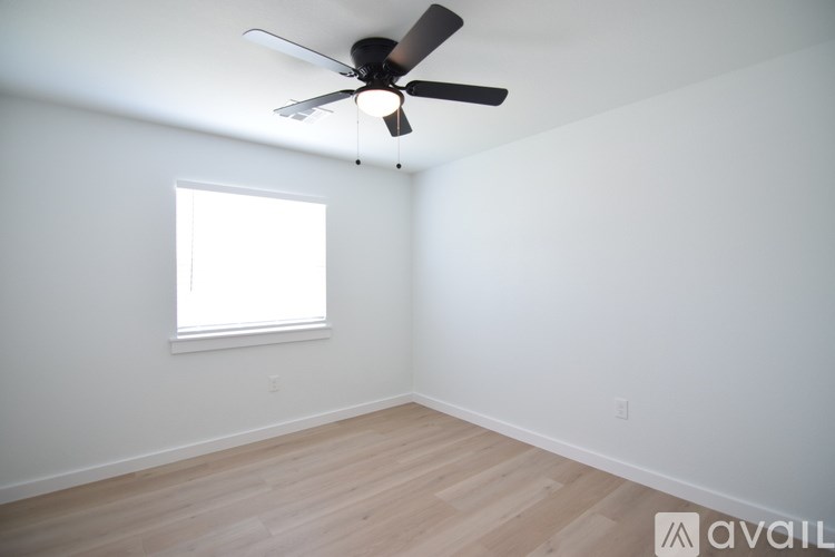 A room with a ceiling fan and a window.
