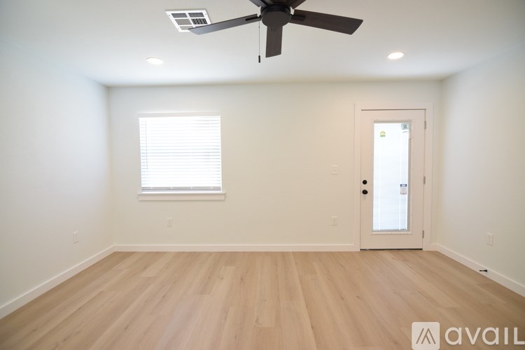 A room with a ceiling fan and a door.