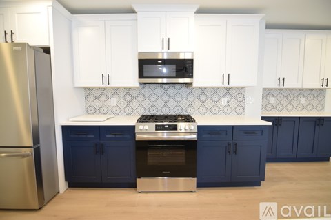 A kitchen with white cabinets and a blue island.