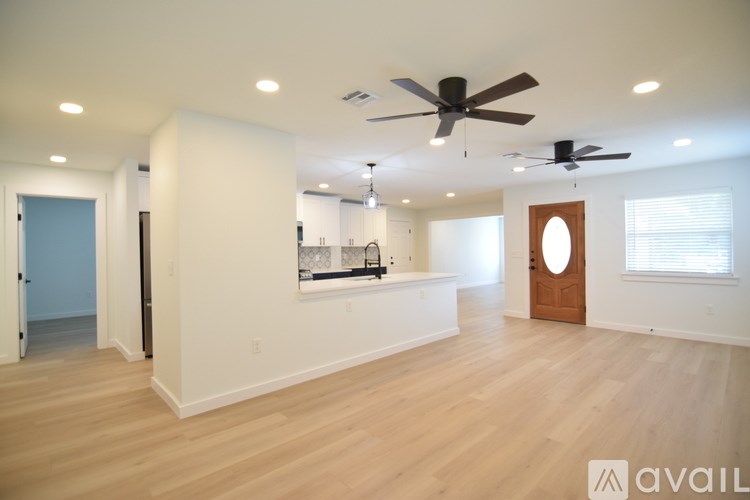 A spacious room with a ceiling fan and lighting fixtures.