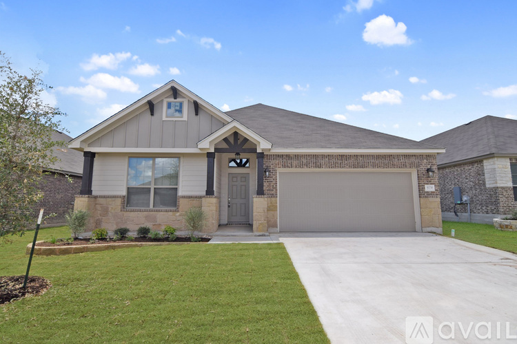 A house with a grey garage door and a brown roof.