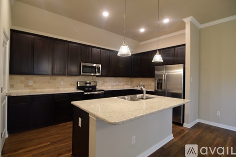 A kitchen with a white counter top and black cabinets.