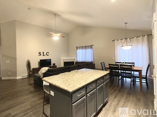 A spacious living room with a kitchen area and a dining table.