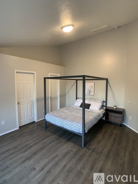 A bedroom with a four poster bed and a nightstand.