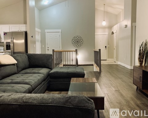 A modern living room with a grey sofa and a glass coffee table.