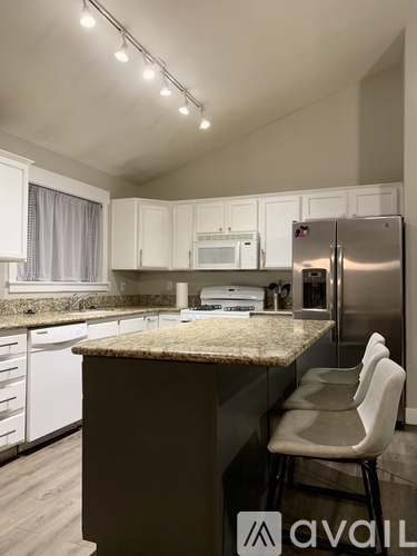 A kitchen with a granite countertop and white cabinets.