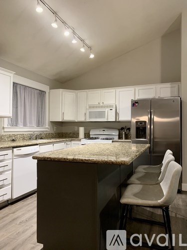 A kitchen with a granite countertop and white cabinets.