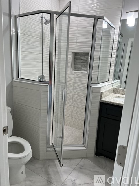 A white toilet is next to a walk-in shower.