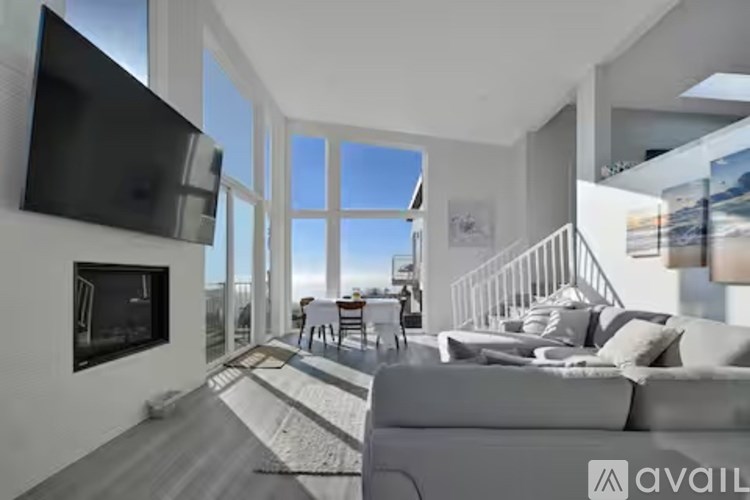 A modern living room with a flat screen TV mounted on the wall.