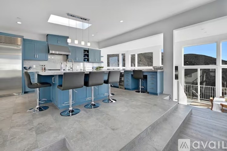 A modern kitchen with blue cabinets and a large island.