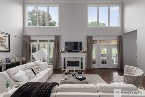 A living room with a white couch and a fireplace.