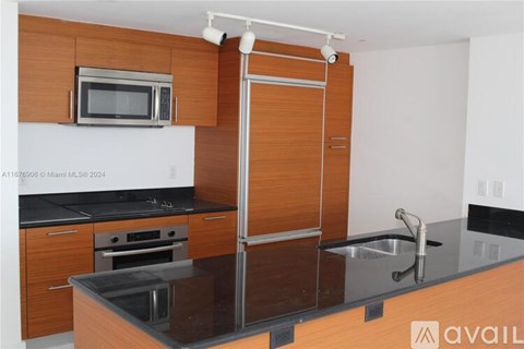 A kitchen with a microwave, oven, sink and refrigerator.