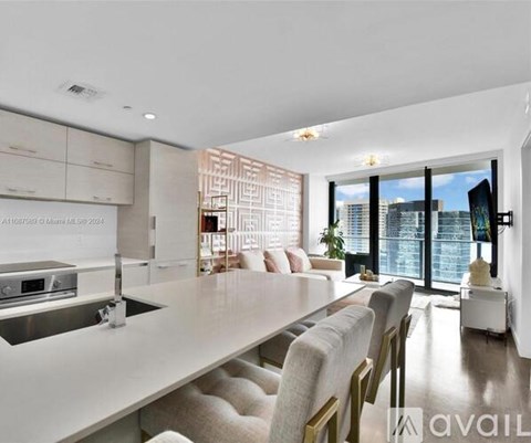 A modern kitchen with a large island and a view of the city.