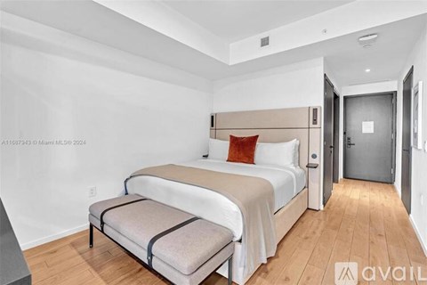 A bedroom with two beds and a bench in the middle.