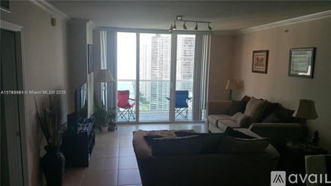 A living room with a couch, chairs, and a television.