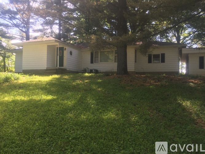 A house with a tree in front of it is for sale.