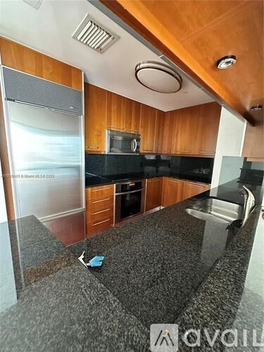 A kitchen with wooden cabinets and a granite countertop.