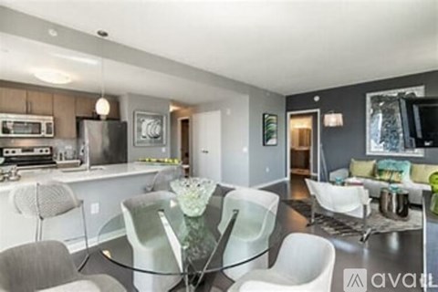 A modern kitchen with a glass table and white chairs.