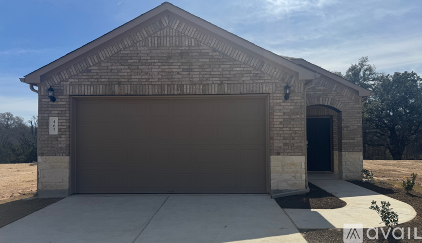 A garage with a brown brick exterior and a brown garage door.