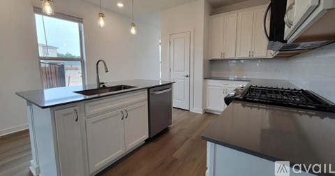 A kitchen with white cabinets and a black countertop.