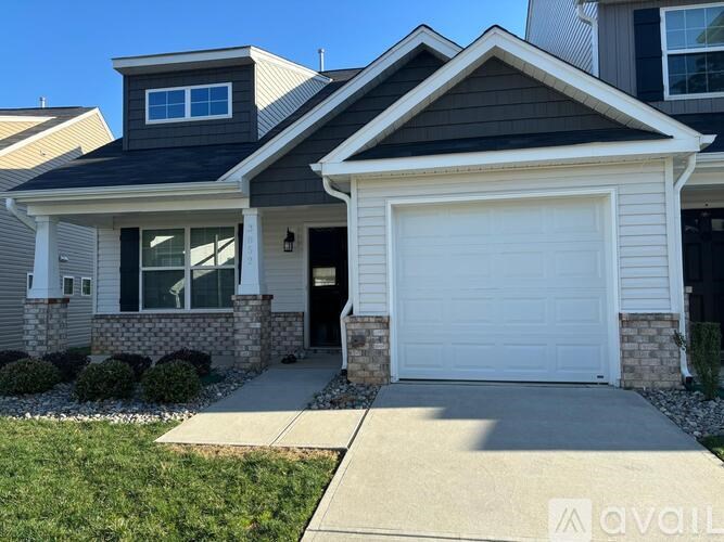 A house with a garage door and a driveway.
