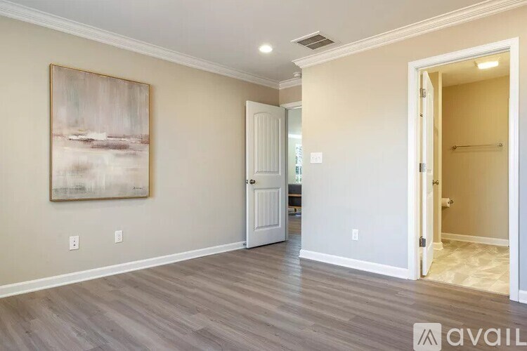 A room with a painting on the wall and a door on the right.