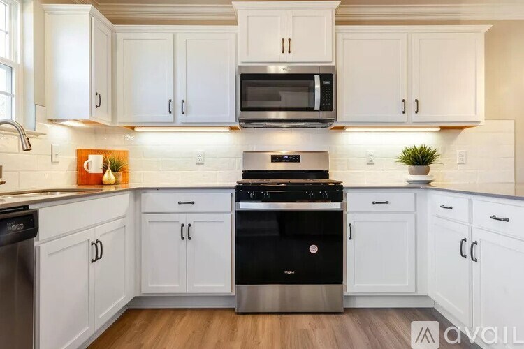 A kitchen with white cabinets and a black stove top oven.