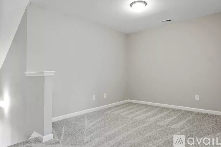 A room with a striped carpet and a white pillar.