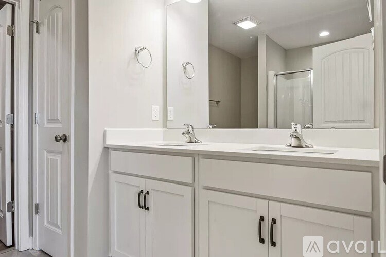 A bathroom with a white sink and cabinets.