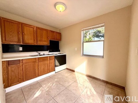 A kitchen with wooden cabinets and a black refrigerator.