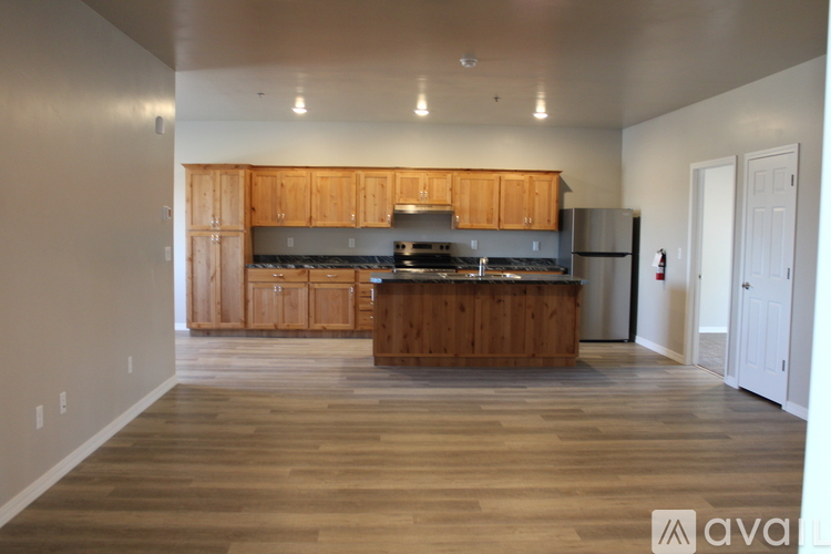 A kitchen with wooden cabinets and a wooden floor.