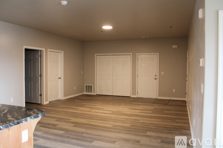 A spacious room with wooden floors and white walls.