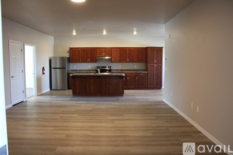 A spacious kitchen with wooden cabinets and a refrigerator.