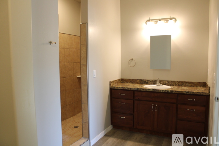 A bathroom with a sink, mirror, and cabinets.