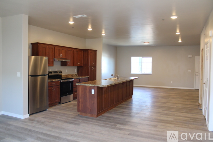 A kitchen with wooden cabinets and a stainless steel refrigerator.