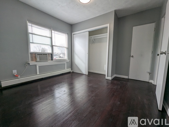 A room with a window and a wooden floor.