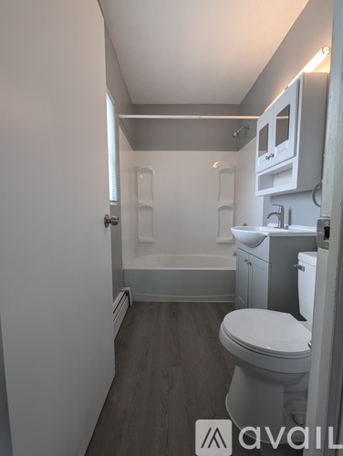 A small bathroom with a toilet, sink and bathtub.